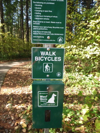 Rules of the park and dog waste bag container at trailhead